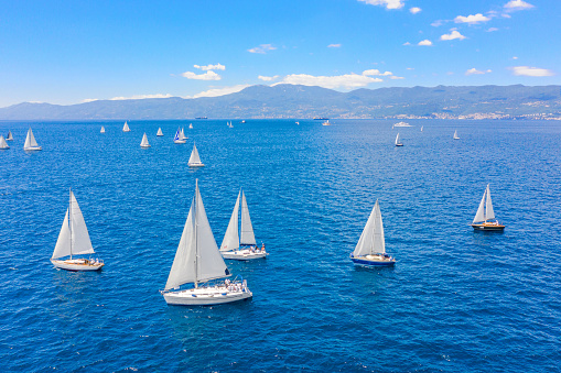 Sailing ship yachts with white sails, deep blue sky