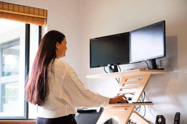 istock Female working on desktop computer at her standing desk 1411421789