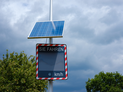 Basel, Switzerland - July 4 2022: Speed sign with solar powered display: going below speed limit. cloudy summer day