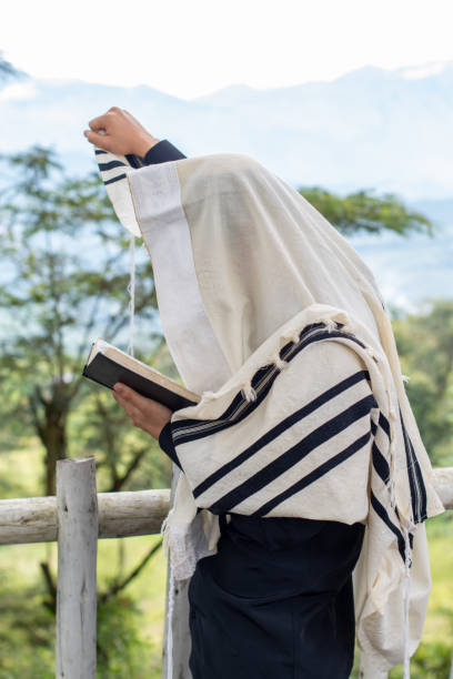 jude betet und liest den siddur, während er seinen rechten arm in den himmel hebt. - judaism jewish ethnicity hasidism rabbi stock-fotos und bilder