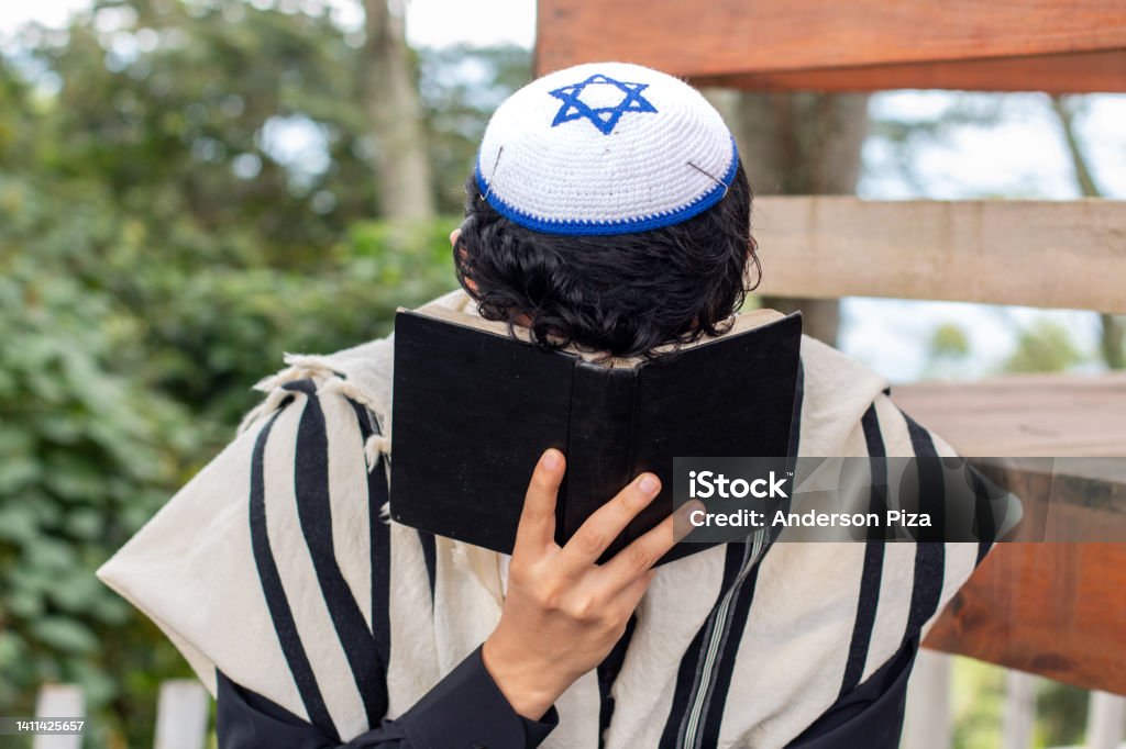 Frontal view of a Jew praying to his god and curving his face with a siddur. Judaism Stock Photo