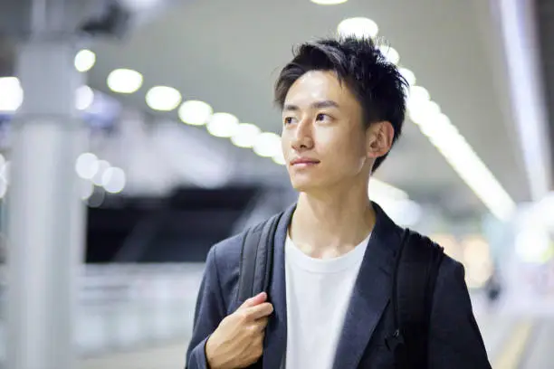 Photo of Young businessman and train station at night