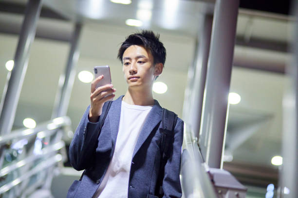 istock Young businessman and train station at night 1411428329