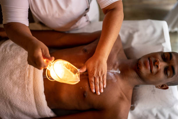 masażystka wylewająca olej na plecy klienta - massaging men beauty spa beauty treatment zdjęcia i obrazy z banku zdjęć
