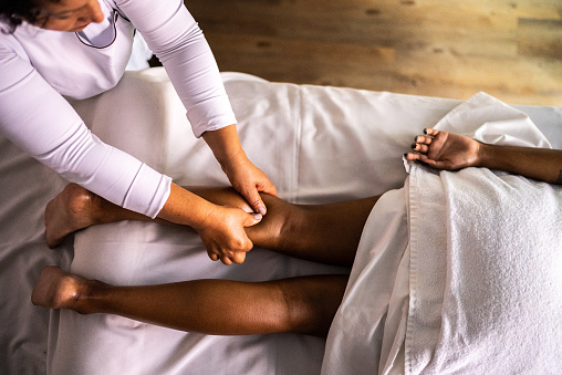 Massage therapist massaging a woman at a beauty spa