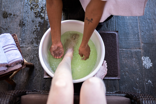Beautician doing a foot bath in a woman at a beauty spa