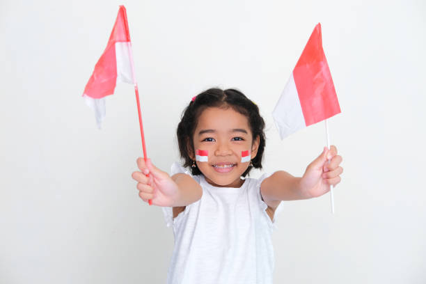 istock Indonesia kid smiling happy while showing two small country flag 1411434145