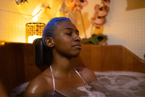 Young woman on a bathtube at a beauty spa