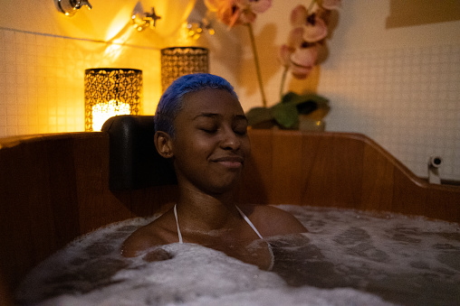 Young woman on a bathtube at a beauty spa