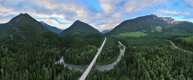 Drone view of the Trans Canadian Highway through a lush green forest and a bridge over the river. Beauty in nature. Environmental conservation backgrounds.