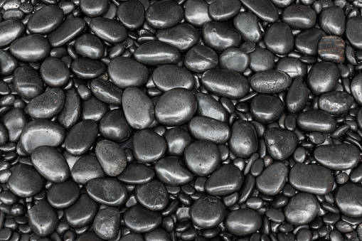 Black pebbles for texture and background smooth natural beach stones or rocks.