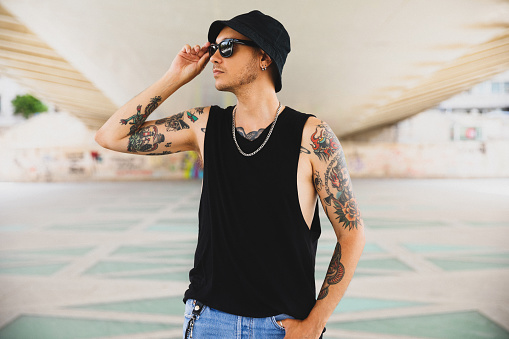 Young man tattooed is wearing black tank top\nTemplate mockup blank tank top
