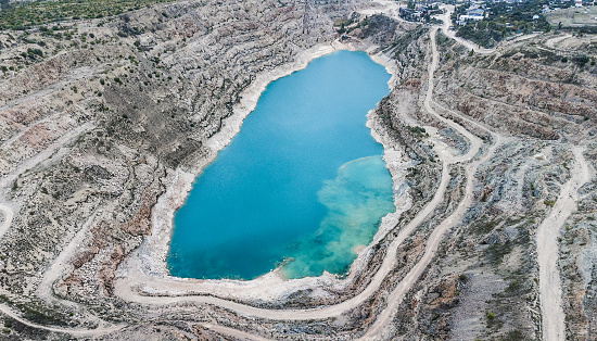 Top view of open pit quarry full of blue water