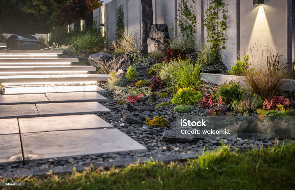 Illuminated Backyard Garden by LED Lights Illuminated Residential Backyard Garden by LED Lights. Modern Architectural Concrete Wall and Stairs Elements Design. Landscaped Stock Photo