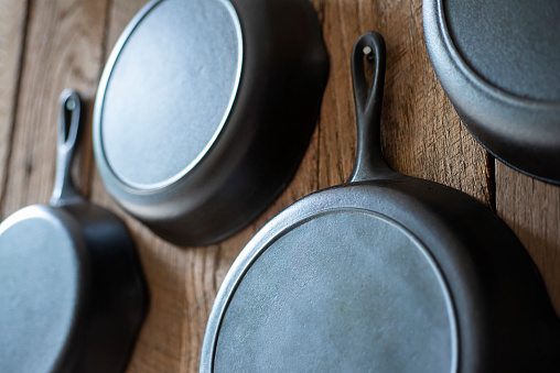 Cast Iron Skillets Hanging on a Rustic Wooden Wall