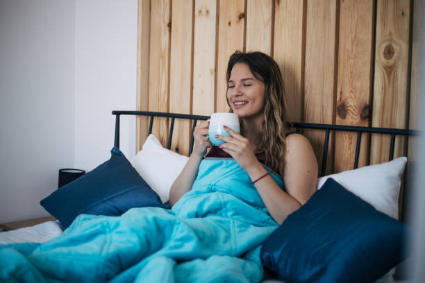 istock Beautiful young woman drinking coffee in bed. 1411443168