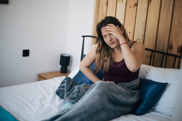 Young woman in bed having menstrual pain stock photo