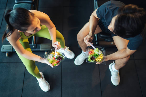 top view asiatischer mann und frau gesunde ernährung salat nach dem training im fitnessstudio. - sport food exercising eating stock-fotos und bilder