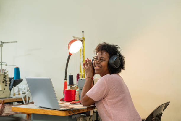 istock Afro woman is in her sewing workshop taking online design classes through her laptop 1411446003