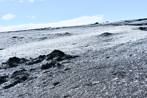 Closeup of dark-colored glacier because the ice is mixed with the black ash of the volcano northen Europe