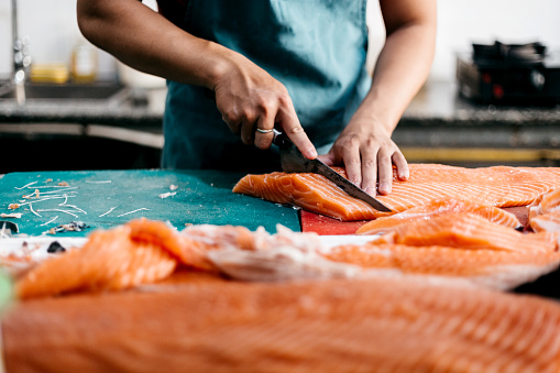 The chef is filleting fresh salmon in the kitchen high resolution stock photo