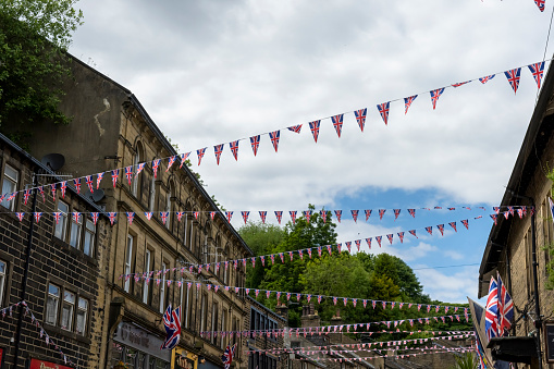 This is historic Haworth, Yorkshire, England, UK, home of the Bronte sisters.  The village is bedecked in bunting and union flags as it celebrates the Platinum Jubilee of Queen Elizabeth II.