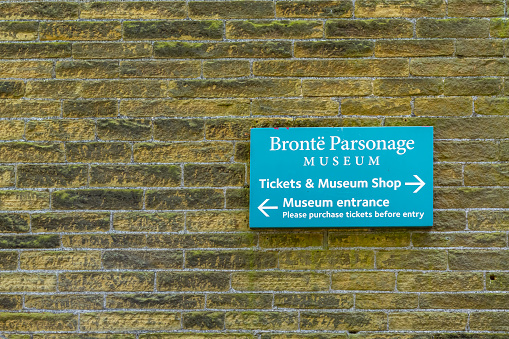 This is the Haworth Parsonage museum sign where the Bronte sisters lived and wrote.  It is in the historic village of Haworth in North Yorkshire and has been turned into a museum of the Bronte family.