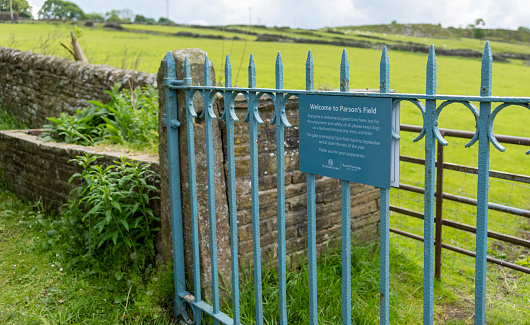 Sign giving the history of the Parson's Field Meadow near the Bronte parsonage in Haworth, Yorkshire, England, UK.
