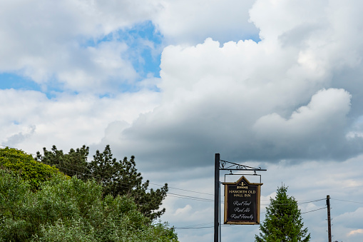 This is historic Haworth, Yorkshire, England, UK, home of the Bronte sisters.  This image is of the sign for Haworth Old Hall Inn, a pub near the bottom of the high street.