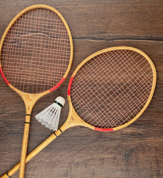 istock Two rackets and a shuttlecock for playing badminton on a wooden background. 1411454114