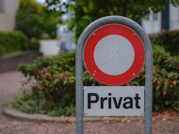 Shallow focus of a generic Private sign seen nailed to a wooden post at the edge of private gardens in London, UK.