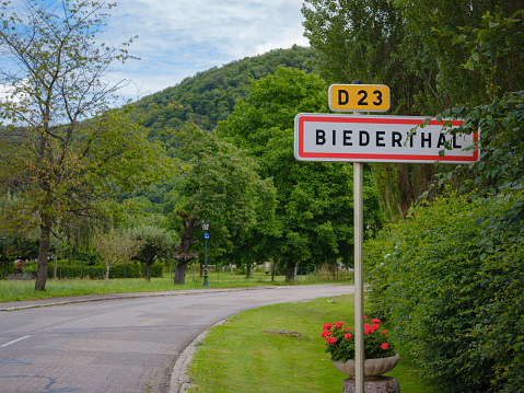 Road sign at entrance of Swiss mountain village Biederthal on summer day.