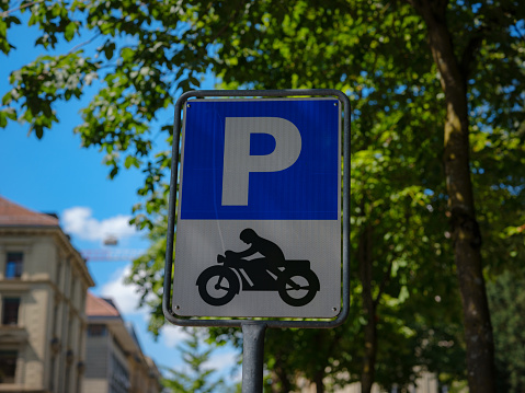 Sign for a motorcycle parking area over city street Basel.