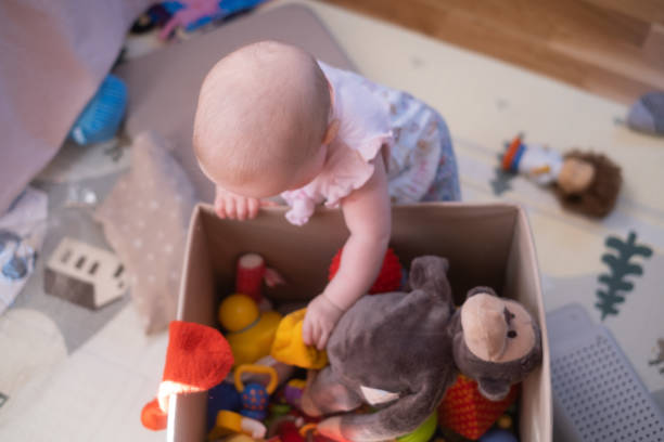 istock Funny caucasian baby choosing a toy from box. 1411458933
