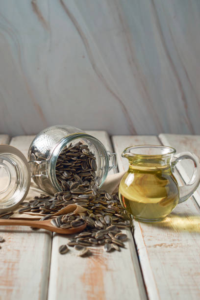 istock Sunflower oil, with seeds aside in a rustic setting. 1411460125