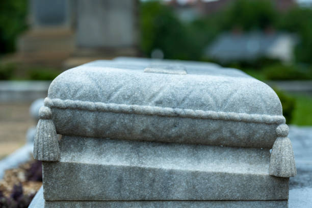 Tombstone in graveyard/burial ground from the 1800s on a sunny summer day in July. The image is part of a series of images of graveyard tombstone/sculptures captured with a full frame digital camera with a sharp, short 85mm prime telephoto lens at f/2.8 and low ISO (100) resulting in large, noiseless images of professional quality.