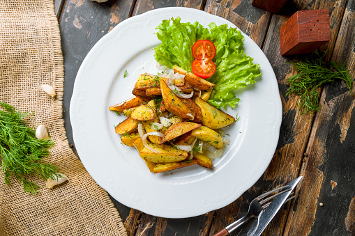 fried potatoes with onions top view on old wooden table