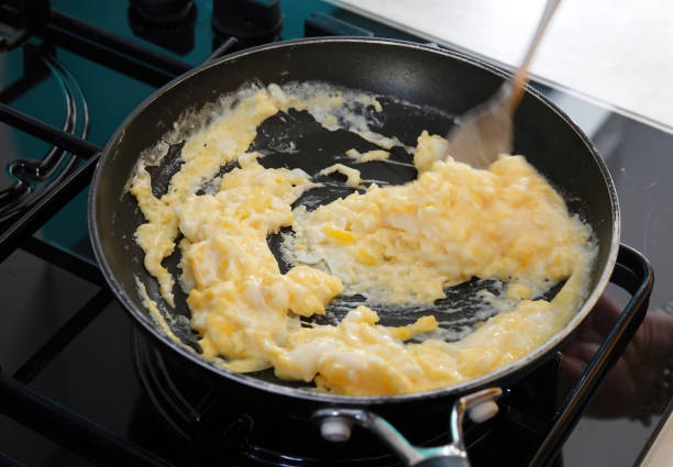 istock Scrambled egg being whipped in a frying pan on a stove. 1411473581