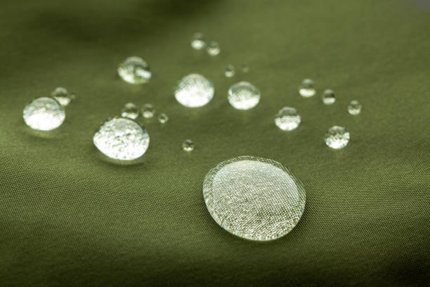 Extreme closeup of beautiful water droplets on waterproof fabric Extreme closeup of beautiful water droplets on dark green waterproof fabric water repellent stock pictures, royalty-free photos & images