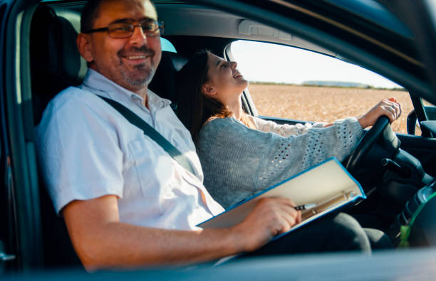 istock Instructor and young female student in the car 1411476668