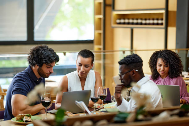 istock Busy businesspeople sit at the dinner table in a restaurant, working on laptops and having an important meeting. 1411477905