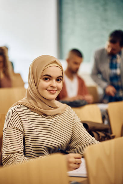 istock Smiling Muslim female student attending a class at the university and looking at camera. 1411478555