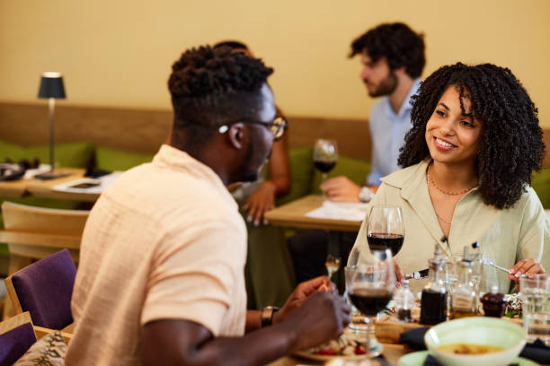 istock A happy multiracial couple sits in a restaurant, chatting and having dinner together. 1411478618