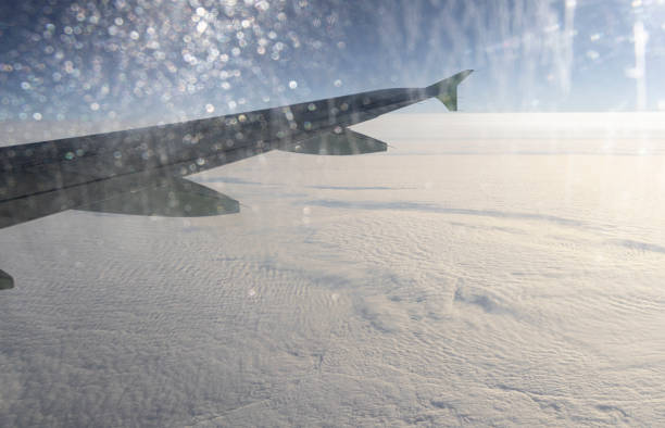 Airplane, only showing the wing while in flight above the clouds.