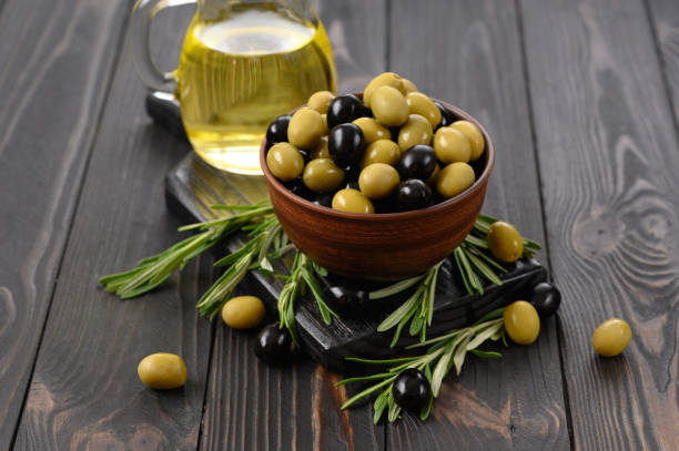 istock Black and green olives on a dark wooden rustic background. 1411483495
