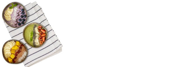 Three plates of fruit smoothies on a tablecloth on the side, flat view. A banner for a website with room for copying. Cherry, blueberry, mango, banana, almond, goji berry.