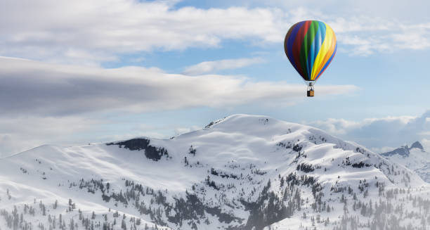 istock Dramatic Mountain Landscape covered in clouds and Hot Air Balloon Flying 1411484031