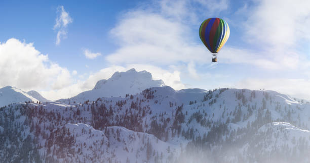 istock Dramatic Mountain Landscape covered in clouds and Hot Air Balloon Flying. 1411484736