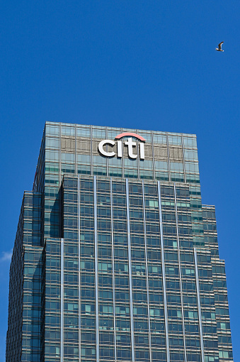 London, England - June 2022: Exterior view of the Citi bank office building in Canary Wharf. a seagull is flying overhead