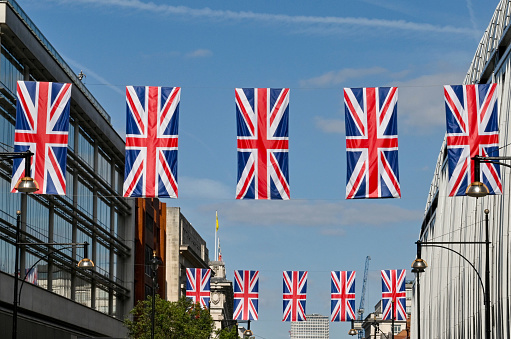 London, England - June 2022: Rows of Union Jack flags hanging over Oxford Street, to commemorate the Jubilee. No people.